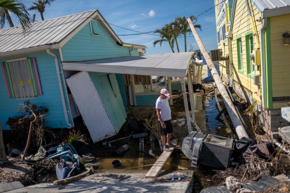 A man stands in front of his destroyed house in the aftermath of Hurricane Ian in Matlacha, Fla.