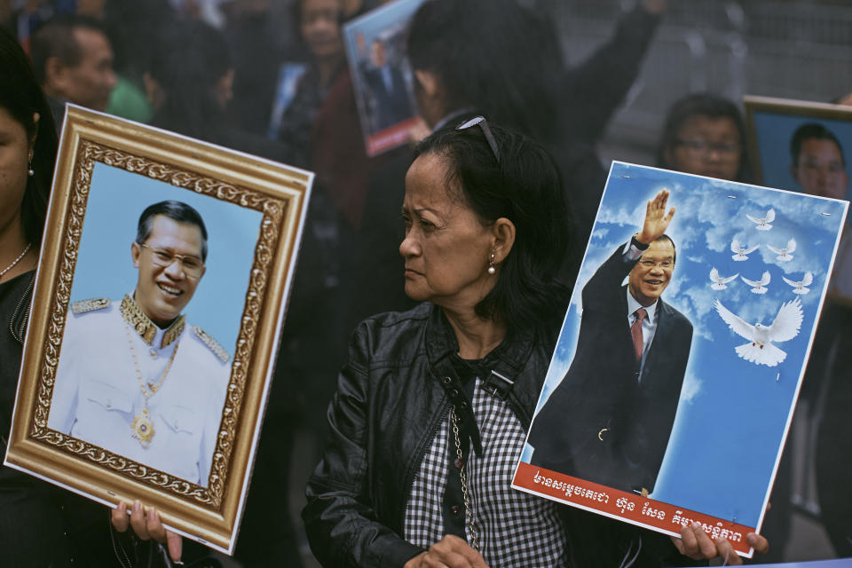 A supporter of the Cambodian Prime Minister Hun Sen carries a picture of him as she demonstrates outside United Nations headquarters on Friday, Sept. 28, 2018, in New York. (AP Photo/Andres Kudacki)