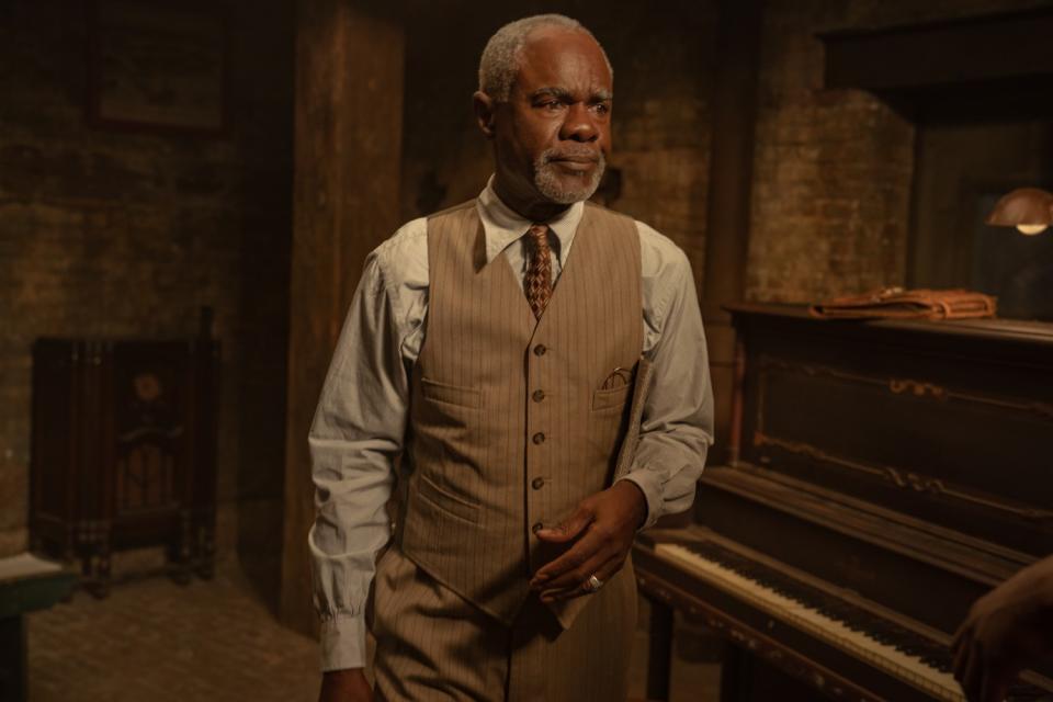 Glynn Turman stands next to a piano in a room in "Ma Rainey's Black Bottom."