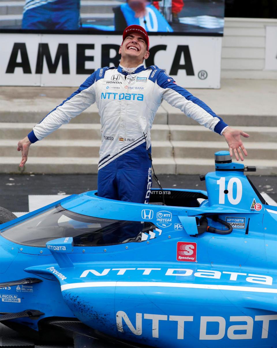 Alex Palou climbs out of his car in victory lane after winning the 2021 NTT IndyCar Series Rev Group Grand Prix at Road America.