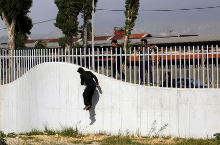 Afghan immigrants jump over a fence into a ferry terminal in the western Greek town of Patras April 28, 2015. REUTERS/Yannis Behrakis