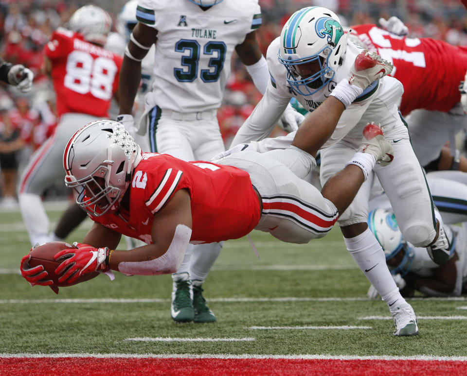 Ohio State running back J.K. Dobbins, left, dives across the goal line past Tulane defensive back Roderic Teamer during the first half of an NCAA college football game Saturday, Sept. 22, 2018, in Columbus, Ohio. (AP Photo/Jay LaPrete)