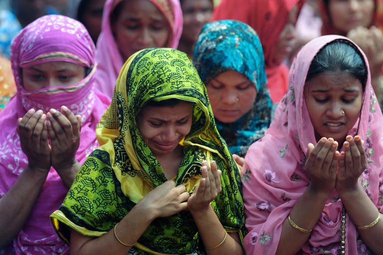 Bangladeshi family members of missing garment workers offer prayers in front of the rubble of a collapsed building in Savar, on the outskirts of Dhaka, on May 14, 2013. There has been virtually no work at Ashulia, home to several hundred garment factories, since the deadly collapse of the garment factory complex near the hub that highlighted appalling safety conditions in the sector