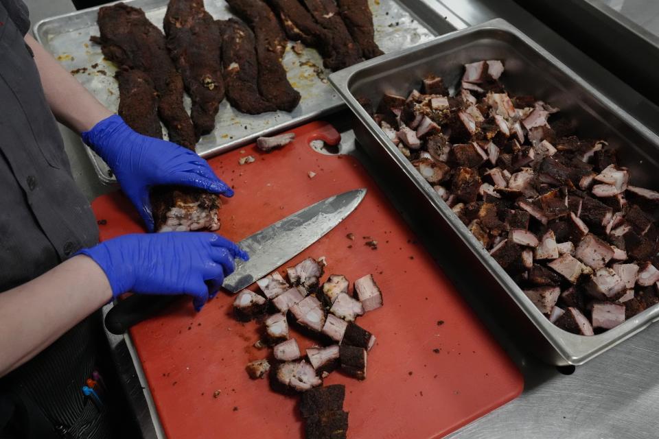 A cook prepares pork rib tips, Wednesday, June 12, 2024, at a barbecue restaurant in Cincinnati. Psychologists have known for years now that men tend to eat more meat than women, but a study of people around the world now reveals that that's true across cultures. (AP Photo/Joshua A. Bickel)