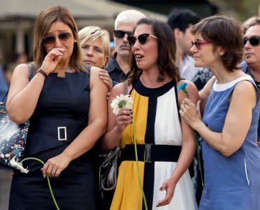 Relatives react before placing flowers in memory of victims of the twin Islamist attacks on the Catalan capital and the coastal town of Cambrils that killed 16 people, during a ceremony to mark the first anniversary of the attacks at Las Ramblas, central Barcelona, Spain, August 17, 2018. REUTERS/Albert Salame