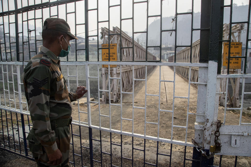 An Indian paramilitary soldier stands guard near the bridge on Tiau river along the India-Myanmar border in Mizoram, India, Saturday, March 20, 2021. Several Myanmar police officers who fled to India after defying army orders to shoot opponents of last month’s coup are urging Prime Minister Narendra Modi’s government to not repatriate them and provide them political asylum on humanitarian grounds.(AP Photo/Anupam Nath)