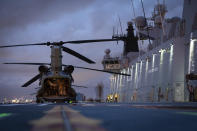 In this photo provided by the Australia Defense Force HMAS Adelaide embarks Chinook Heavy-Lift Helicopters, Wednesday, Jan. 19, 2022, before departing the port of Brisbane, Australia, to provide humanitarian assistance to the Government of Tonga. U.N. humanitarian officials report that about 84,000 people — more than 80% of Tonga's population — have been impacted by the volcano's eruption. (LSIS David Cox/Australian Defence Force via AP)