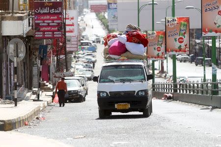 Internally displaced people with luggage ride in a van as they flee from an airstrike on an army weapons depot in Yemen's capital Sanaa May 12, 2015. REUTERS/Mohamed al-Sayaghi