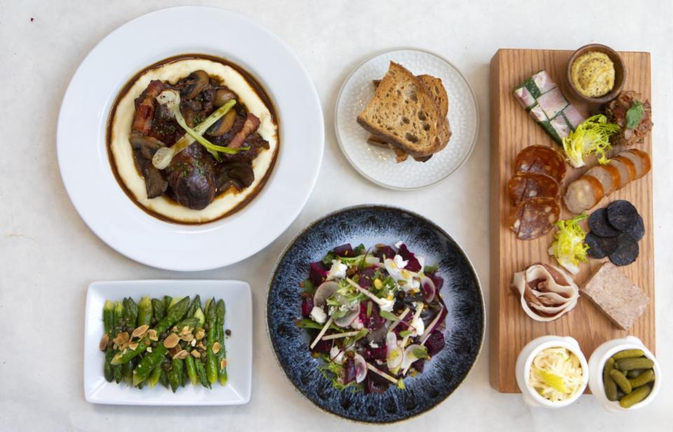 Coq au vin, clockwise from left, a charcuterie board, beet salad and asparagus at Perle in Pasadena.