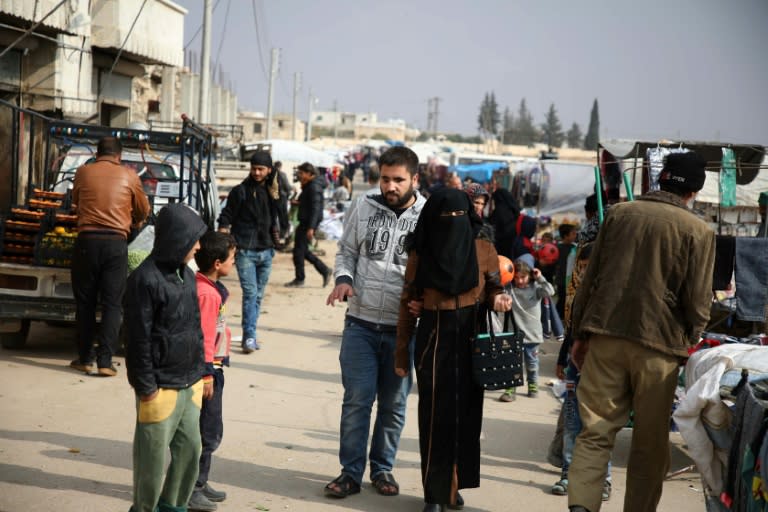 Syrian Ahmad Talha, a student in computer sciences and former rebel fighter who lost his sight as a result of a gunshot wound, walks with his wife Samia in the market of rebel-held Anjara town in Aleppo province