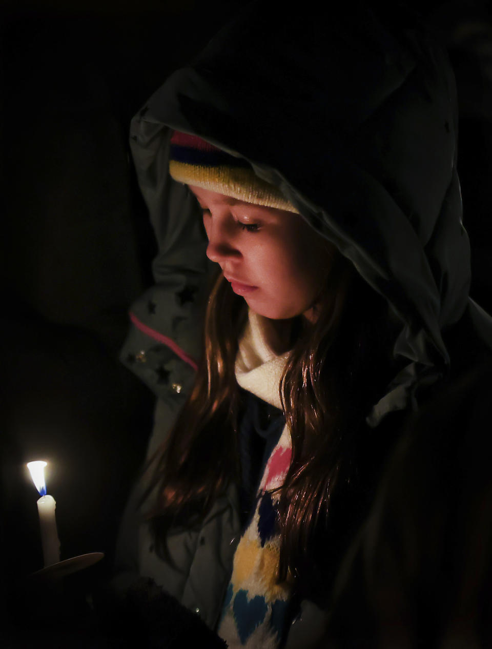 A young mourner looks down at her candle during a vigil for Tyre Nichols, who died after being beaten by Memphis police officers, in Memphis, Tenn., Thursday, Jan. 26, 2023. (Patrick Lantrip/Daily Memphian via AP)