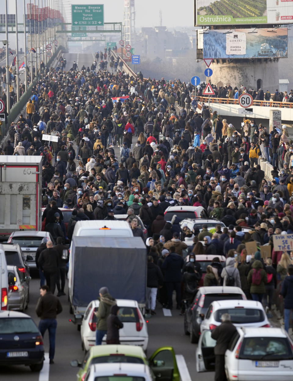 Protesters stand on the highway during a protest in Belgrade, Serbia, Saturday, Dec. 4, 2021. Thousands of protesters have gathered in Belgrade and other Serbian towns and villages to block roads and bridges despite police warnings and an intimidation campaign launched by authorities against the participants. Thousands of protesters have gathered in Belgrade and other Serbian towns and villages to block roads and bridges despite police warnings and an intimidation campaign launched by authorities against the participants. (AP Photo/Darko Vojinovic)