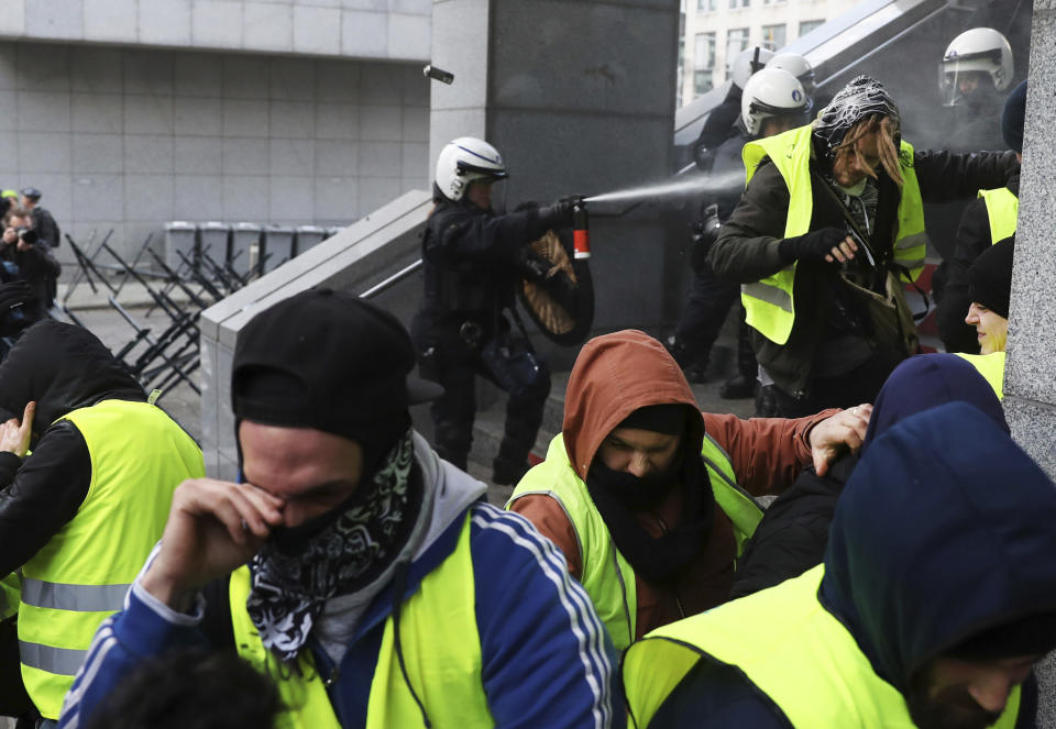 Police spray protestors with pepper spray during a demonstration in Brussels, Saturday, Dec. 8, 2018. Hundreds of police officers are being mobilized in Brussels Saturday, where yellow vest protesters last week clashed with police and torched two police vehicles. More than 70 people were detained. (AP Photo/Francisco Seco)