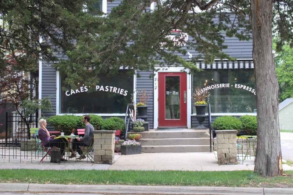 People sit outside Deluxe Cakes and Pastries in Iowa City, May 18. The bakery is located on Summit Street.