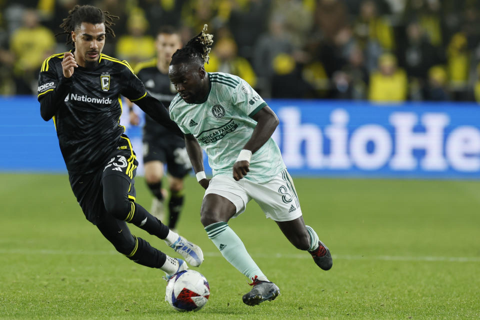 Atlanta United's Tristan Muyumba, right, tries to dribble past Columbus Crew's Mohamed Ramzdine Farsi during the first half of an MLS playoff soccer match Sunday, Nov. 12, 2023, in Columbus, Ohio. (AP Photo/Jay LaPrete)