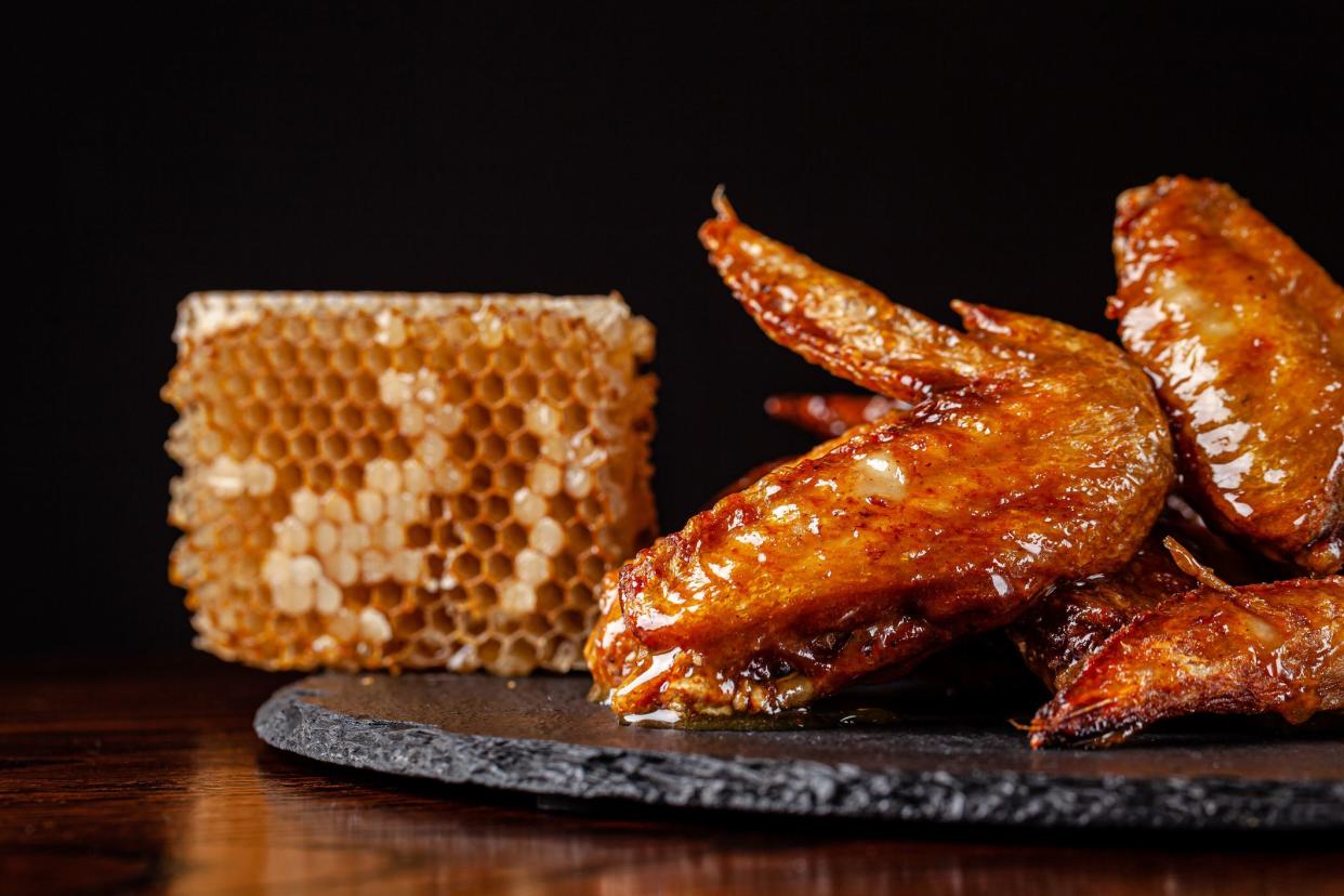 American cuisine. Fried chicken wings glazed in honey sauce on a black background. background image, copy space text