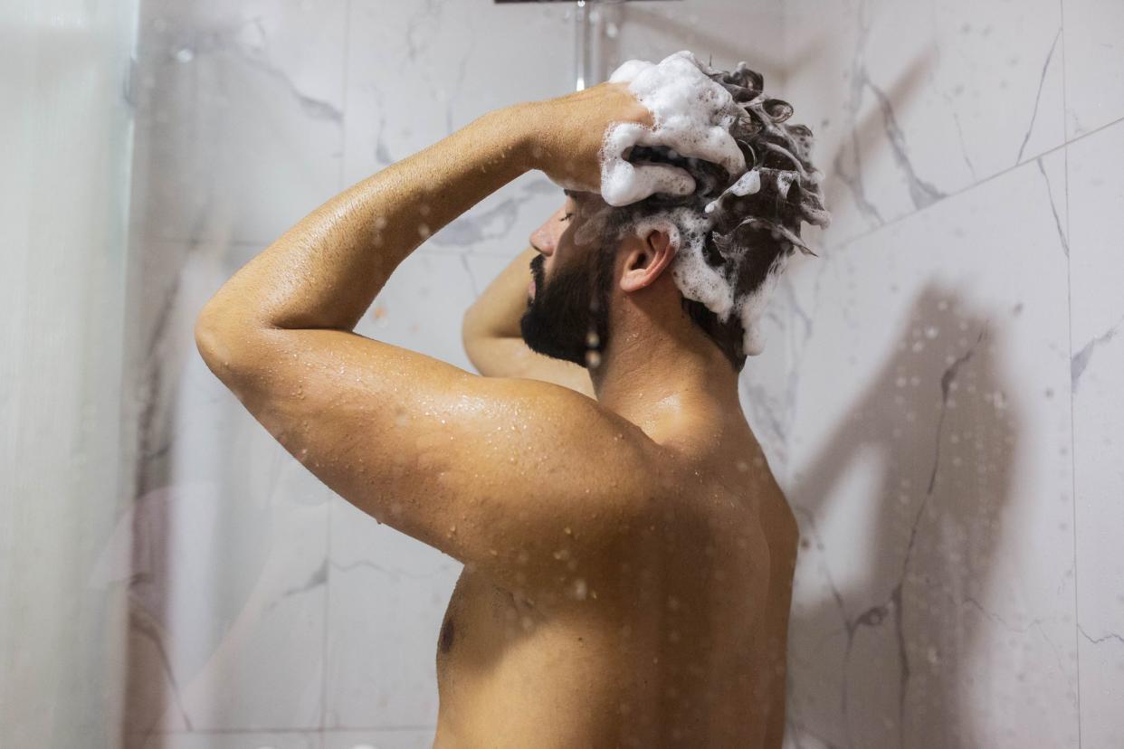 Handsome man take a shower and care of hair and body