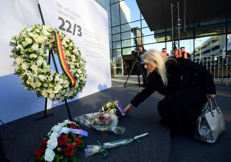 A woman places a bunch of flowers during a memorial at Brussels' international airport in Zaventem