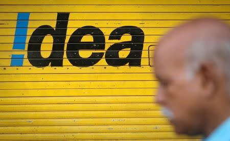 A man walks past a shop displaying Idea Cellular Ltd's logo on its shutters in Mumbai April 28, 2014. REUTERS/Danish Siddiqui/File Photo