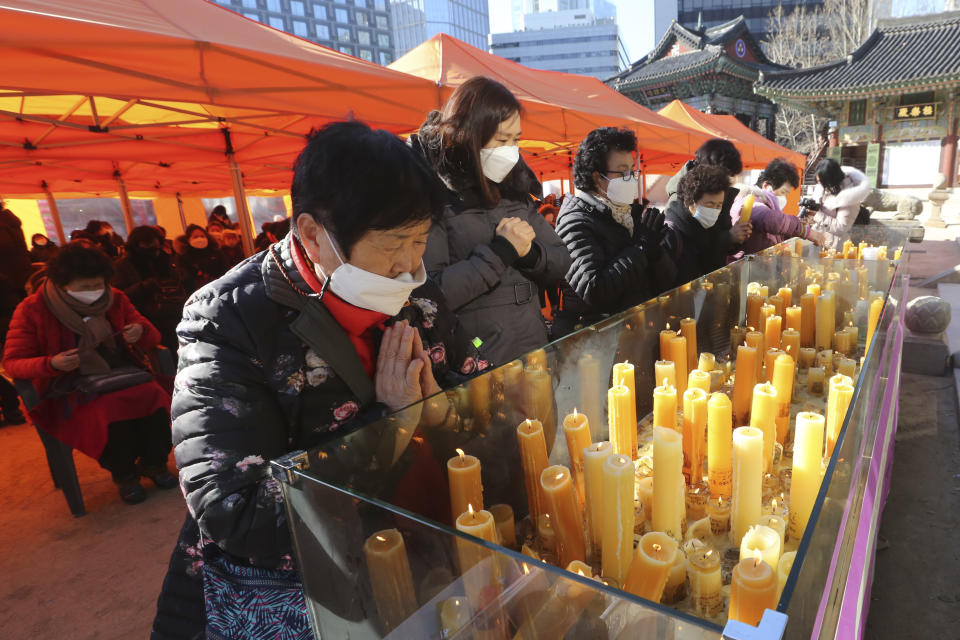 Parents pray during a special service to wish for their children's success in the college entrance exams at the Jogyesa Buddhist temple in Seoul, South Korea, Thursday, Dec. 3, 2020. Hundreds of thousands of masked students in South Korea, including dozens of confirmed COVID-19 patients, took the highly competitive university entrance exam Thursday despite a viral resurgence that forced authorities to toughen social distancing rules. (AP Photo/Ahn Young-joon)