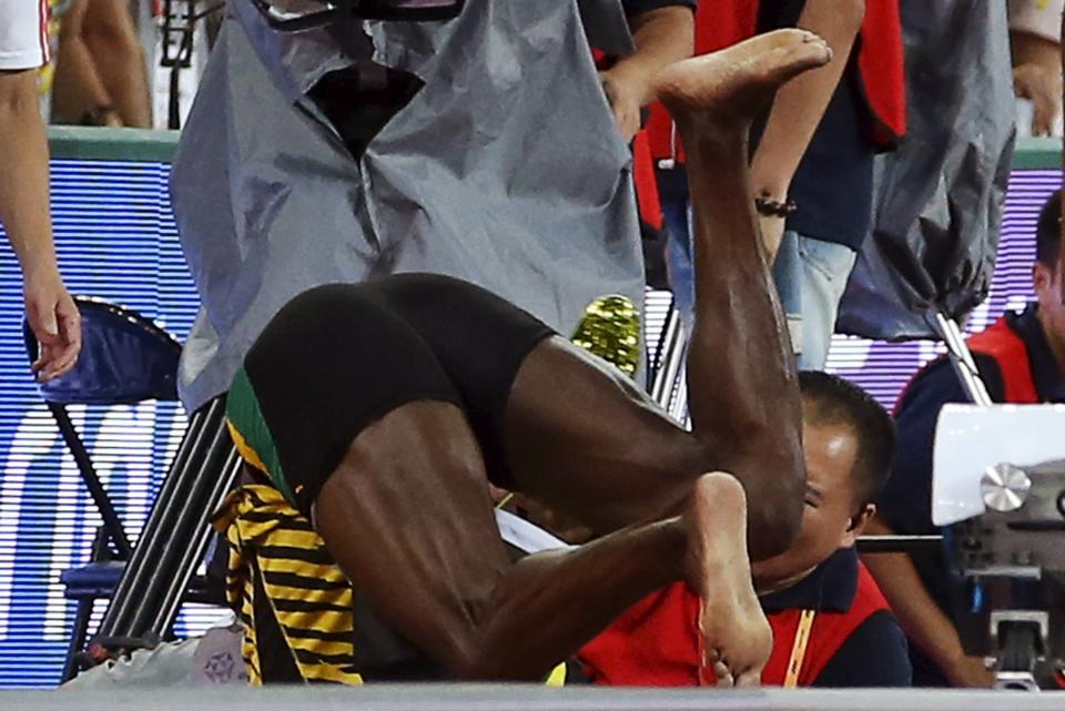 Usain Bolt of Jamaica collides with a cameraman on a segway after the men's 200m final during the 15th IAAF World Championships at the National Stadium in Beijing