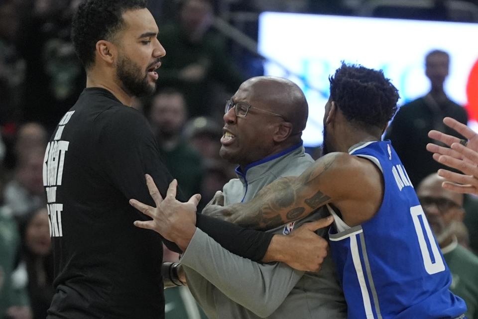 Sacramento Kings head coach Mike Brown is restrained bt Malik Monk as he argues a call during the second half of an NBA basketball game against the Milwaukee Bucks Sunday, Jan. 14, 2024, in Milwaukee. The Bucks won 143-142 in overtime. (AP Photo/Morry Gash)