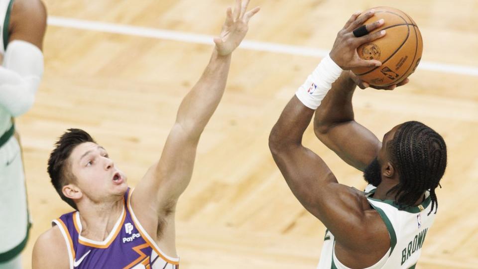 Boston Celtics guard Jaylen Brown (R) shoots over Phoenix Suns guard Grayson Allen