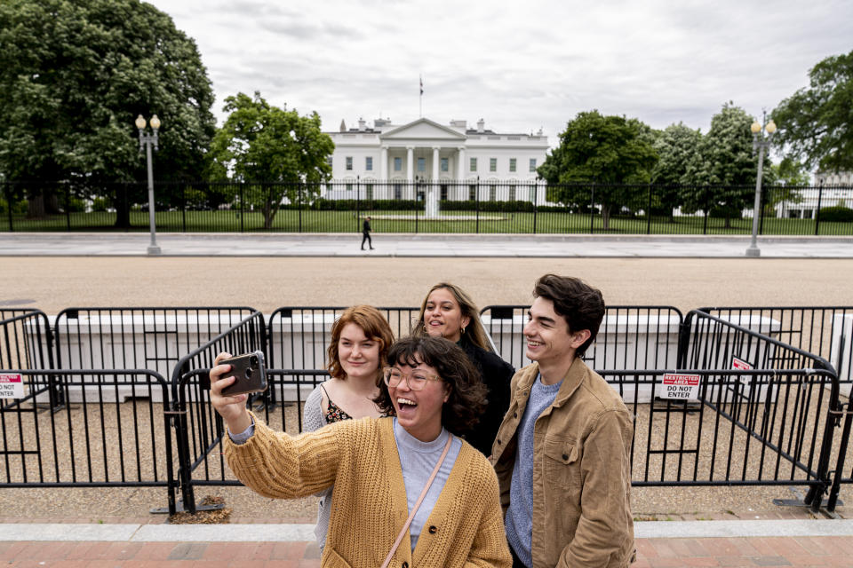 From left, Eliana Lord, Carly Mihovich, Stephanie Justice, and Nick Hansen, visiting from Columbia, S.C., take a photo at Lafayette Park, across the street from the White House, after it reopens in a limited capacity in Washington, Monday, May 10, 2021. Fencing remains in place around the park which will allow the Secret Service to temporarily close the park as they deem necessary. (AP Photo/Andrew Harnik)