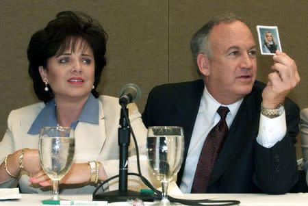 Patsy Ramsey and her husband, John Ramsey (R), produce a picture of Jon-Benet Ramsey during a press conference in Atlanta where they released the results of an independent lie detector test, May 24, 2000. REUTERS/Stringer -