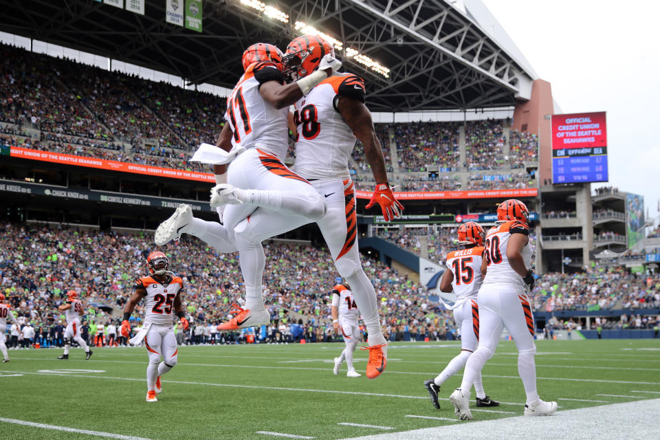 SEATTLE, WASHINGTON - SEPTEMBER 08: John Ross #11 (L) celebrates with Joe Mixon #28 of the Cincinnati Bengals after scoring a 33 yard touchdown pass against the Seattle Seahawks in the second quarter during their game at CenturyLink Field on September 08, 2019 in Seattle, Washington. (Photo by Abbie Parr/Getty Images)