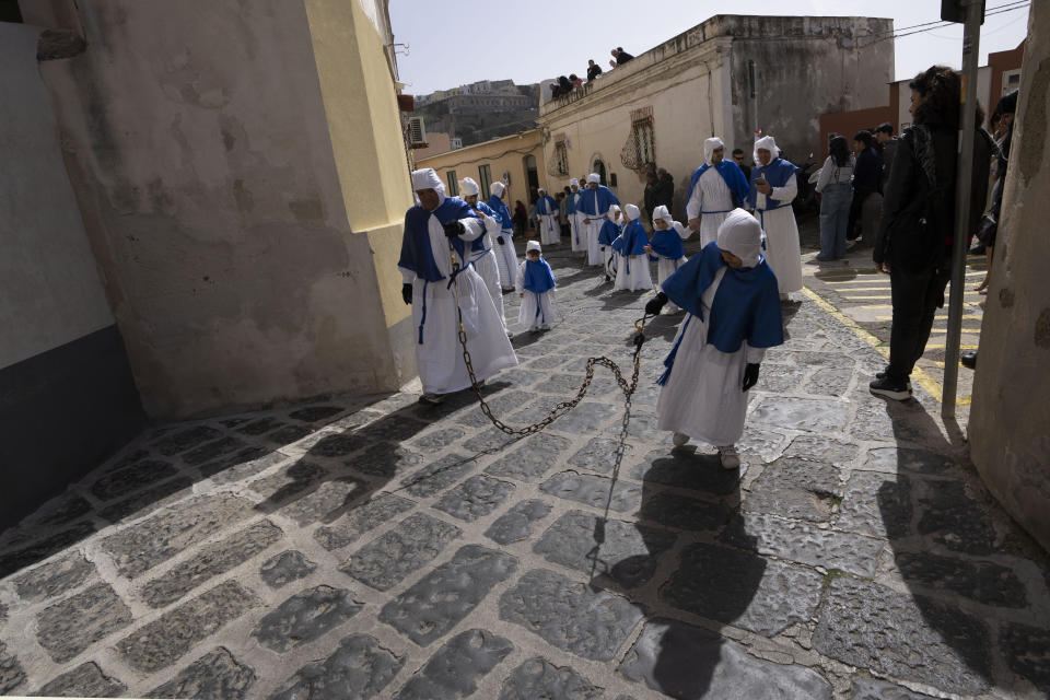 Faithful carry chains during a procession in Procida Island, Italy, Friday, March 29, 2024. Italy is known for the religious processions that take over towns big and small when Catholic feast days are celebrated throughout the year. But even in a country where public displays of popular piety are a centuries-old tradition, Procida's Holy Week commemorations stand out. (AP Photo/Alessandra Tarantino)