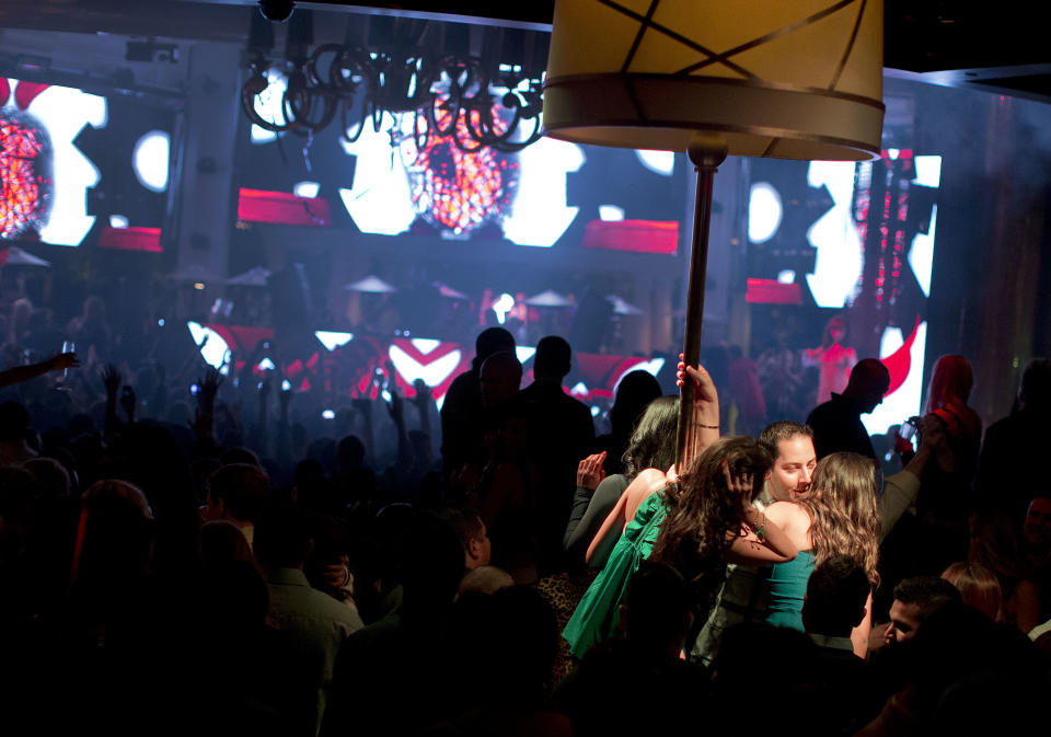 With a private table spotlighted, right, revelers dance to the music played by DJ Afrojack inside the XS nightclub in Las Vegas on Sunday, Jan. 20, 2013. (AP Photo/Julie Jacobson)