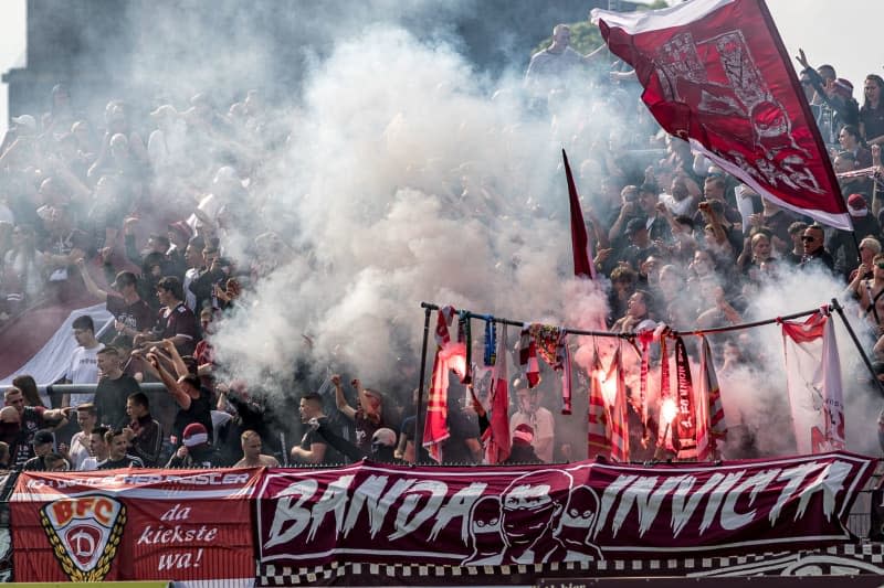 BFC Dynamo fans burn fan paraphernalia from other club during the German Regionalliga Nordost football league soccer match between BFC Dynamo and Energie Cottbus at Sportforum Hohenschoenhausen. Berlin's senator for sports Iris Spranger has expressed her outrage at the fan violence which marred Saturday's fourth-tier game between BFC Dynamo and Energie Cottbus and left 155 police officers injured. Frank Hammerschmidt/dpa