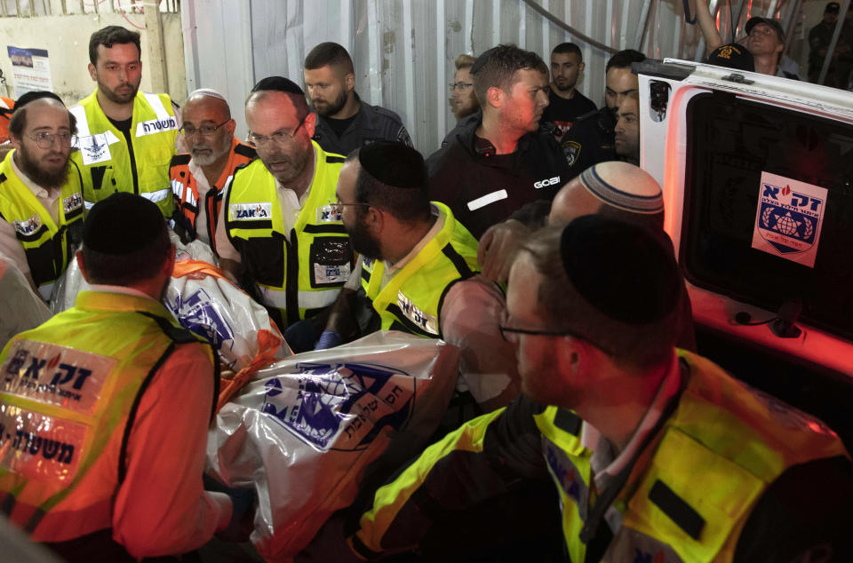 Israeli rescue workers carry a body outside a synagogue in Givat Zeev, outside Jerusalem, Sunday, May 16, 2021. Israeli medics say more than 150 people were injured in a fatal collapse of a bleacher at an uncompleted West Bank synagogue. (AP Photo/Sebastian Scheiner)