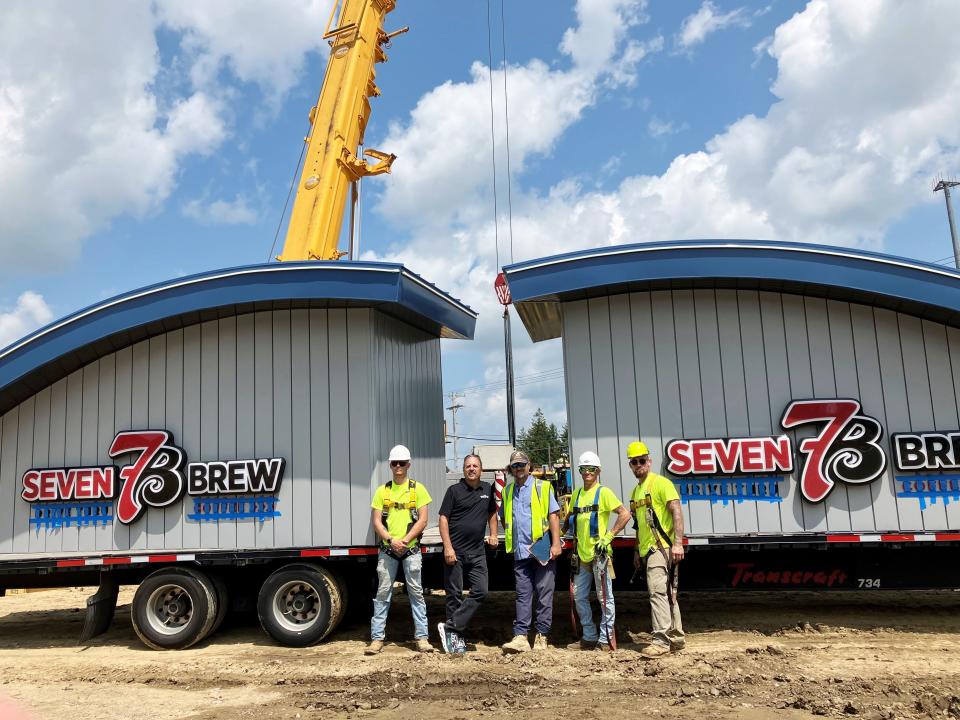 Franchisee Rick Nader, second from left, stands with members of J.L. Moore Construction, of Strongsville, after dropping the new 7 Brew structure on its foundation on Wednesday, at 1361 Maple Ave. in Zanesville. The drive-thru beverage chain, based in Fayetteville, Arkansas, will bring 50 jobs to Muskingum County and open in mid-September.