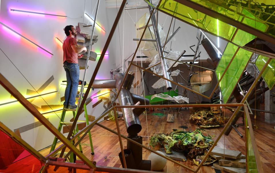 Jeff Kitchen, assistant to artist Judy Pfaff, installs additional lights for the "Picking up the Pieces" exhibit at the Sarasota Art Museum of Ringling College of Art and Design. Half the exhibit recognizes the natural beauty and abundance of Florida. The site-specific half of the installation, pictured here, is a result of Pfaff's exploration of Fort Myers Beach and Sanibel Island following Hurricane Ian.