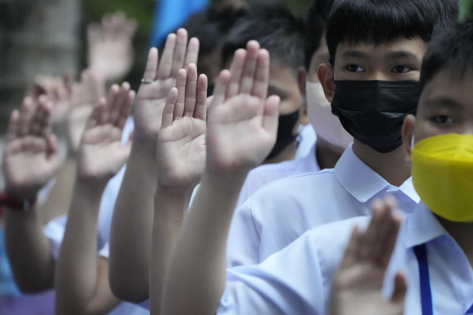 Students raise their hands as they attend a ceremony during the opening of classes at the San Juan Elementary School in metro Manila, Philippines on Monday, Aug. 22, 2022. Millions of students wearing face masks streamed back to grade and high schools across the Philippines Monday in their first in-person classes after two years of coronavirus lockdowns that are feared to have worsened one of the world's most alarming illiteracy rates among children. (AP Photo/Aaron Favila)