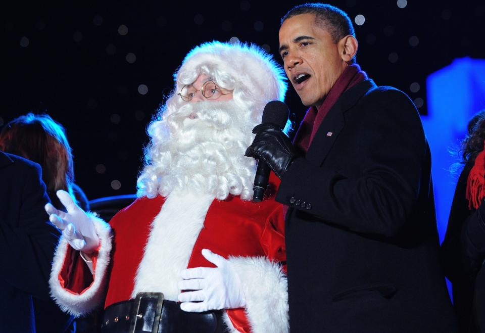 US President Barack Obama sings with Santa during the finale fo the annual lighting of the National Christmas tree December 1, 2011 at The Ellipse in Washington, DC. AFP PHOTO/Mandel NGAN (Photo credit should read MANDEL NGAN/AFP/Getty Images)