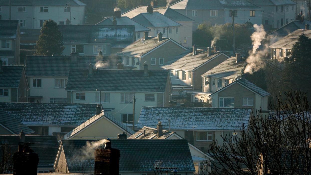 Warm Home Discount MIDSOMER NORTON, UNITED KINGDOM - DECEMBER 15: Smoke rises from chimneys on the roofs of houses in Midsomer Norton, on December 15, 2022 in Somerset, England. Large parts are currently experiencing an artic blast with snow and ice bringing widespread disruption. The UK is currently facing a cost of living crisis, as inflation hits a near-30-year high, the war in Ukraine puts pressure on food prices and rising energy bills squeeze household incomes still further. To add to the misery, many UK households face a further rises in home energy prices as energy price caps are raised (Photo by Matt Cardy/Getty Images)