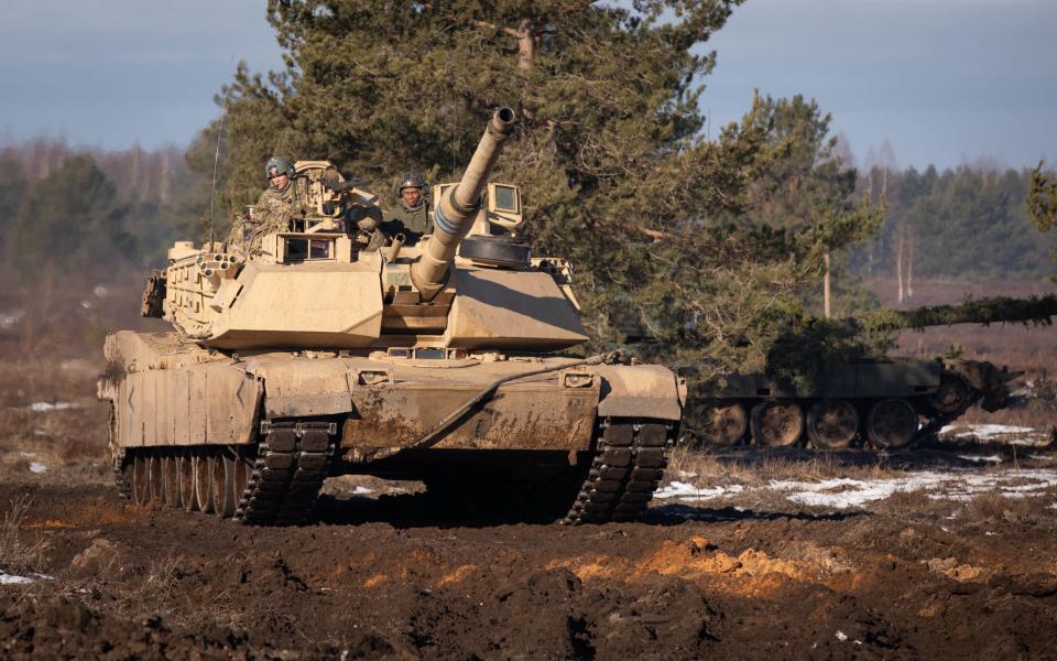 A US Abrams tank races across the Adazi military training area, Latvia on March 23, 2021, to take an objective during exercise Crystal Arrow.