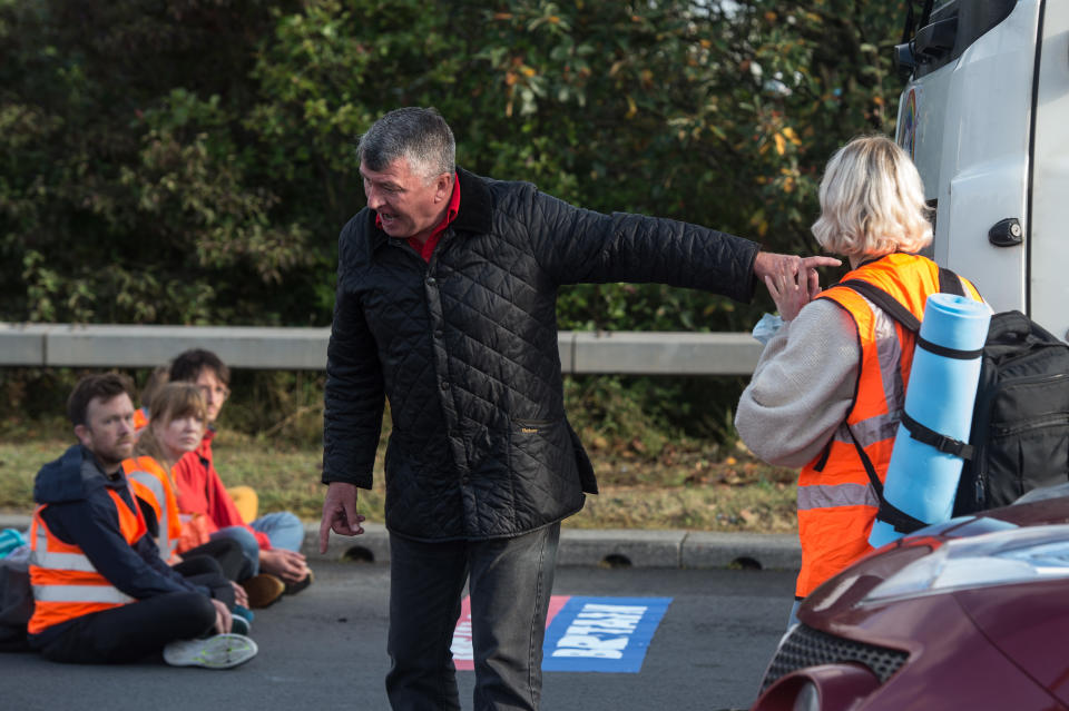 LONDON, ENGLAND - SEPTEMBER 15:  Motorists argue with activists as protesters from the Insulate Britain protest group block a major roundabout near the Dartford crossing and M25 on September 15, 2021 inDartford, England. Several people have been arrested after activists from Insulate Britain blocked junctions on the M25 for the second time this week. The group were protesting against the “lack of progress” in effectively insulating homes in Britain. (Photo by Guy Smallman/Getty Images)