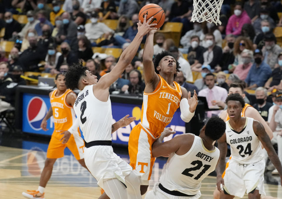 Tennessee guard Kennedy Chandler, center, drives to the rim between Colorado guard KJ Simpson, left, and forward Evan Battey in the first half of an NCAA college basketball game Saturday, Dec. 4, 2021, in Boulder, Colo. (AP Photo/David Zalubowski)