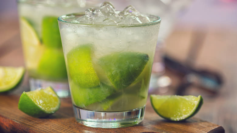 Cocktail with limes next to lime wedges