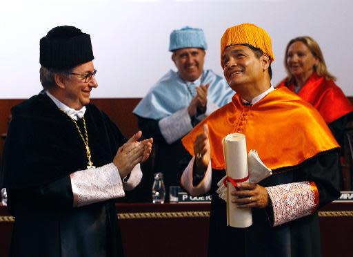 El presidente de Ecuador, Rafael Correa (D) gesticula alegre junto al rector de la Universidad de Barcelona Didac Ramírez tras ser investido este miércoles doctor 'honoris causa' durante ceremonia en la institución (UB) el 23 de abril de 2014. (AFP | Quique García)