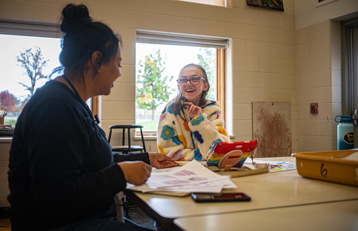 Victoria Peairs, independence and learning support paraprofessional, shares a laugh with Adelaide Duda, a seventh grader, during art class at Kinard Core Knowledge Middle School in Fort Collins on Tuesday.