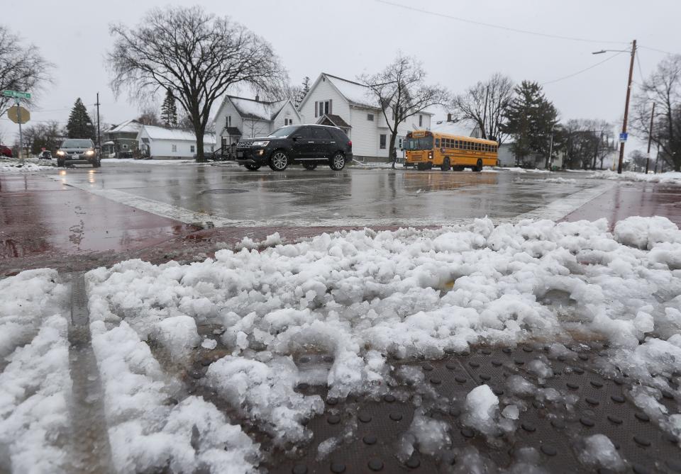 Traffic passes a slushy intersection at South Clay Street and East Walnut Street in Green Bay.
