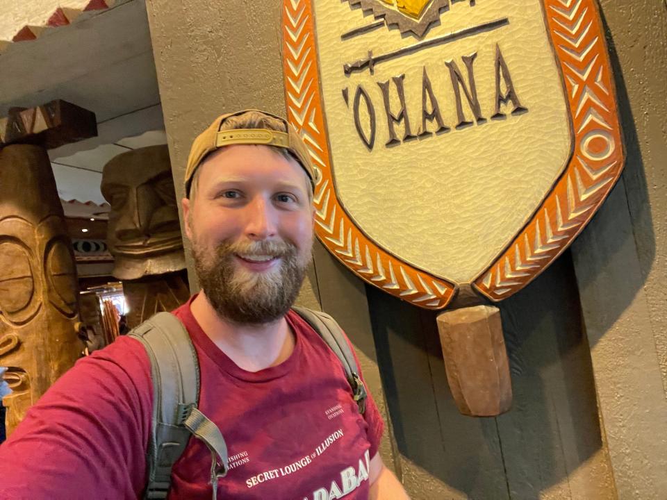 Author stands in front of sign of 'Ohana.