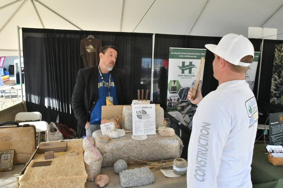Chad Sanden holds a hemp board, twice as strong as oak wood, at the Hemp Building Association booth at the 2020 World Ag Expo.