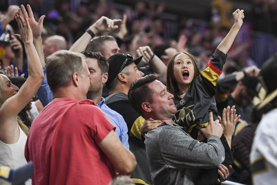 Vegas Golden Knights fans cheer the team's go-ahead goal during the third period of an NHL preseason hockey game against the Arizona Coyotes on Tuesday, Oct. 4, 2022, in Las Vegas. The Golden Knights won 4-3. (AP Photo/Sam Morris)