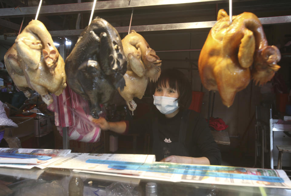 A vendor wears a face masks to help curb the spread of the coronavirus sells cooked chickens at a market in Taipei, Taiwan, Monday, Jan. 25, 2021. (AP Photo/Chiang Ying-ying)